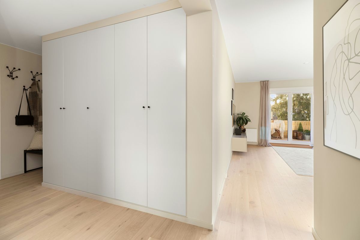 Een witte ingebouwde kast van vloer tot plafond in een gang